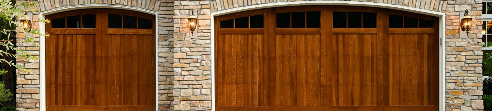 Double wooden garage doors with stone exterior, well-lit and secure, representing Garage Door Repair Taylorsville contact page.