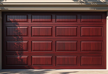 Rich, wood-grain style garage door newly installed on a Taylorsville home, framed by classic beige trim and landscaping